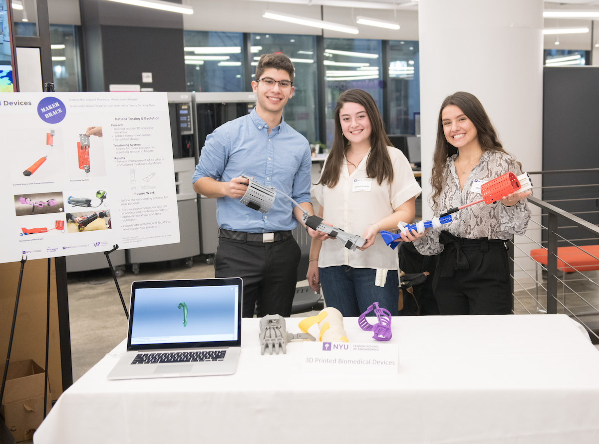 students holding 3d printed devices 