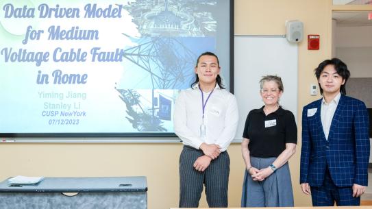 Two students and a sponsor standing to the right of a screen that reads Data Driven Model for Voltage Cable Fault in Rome