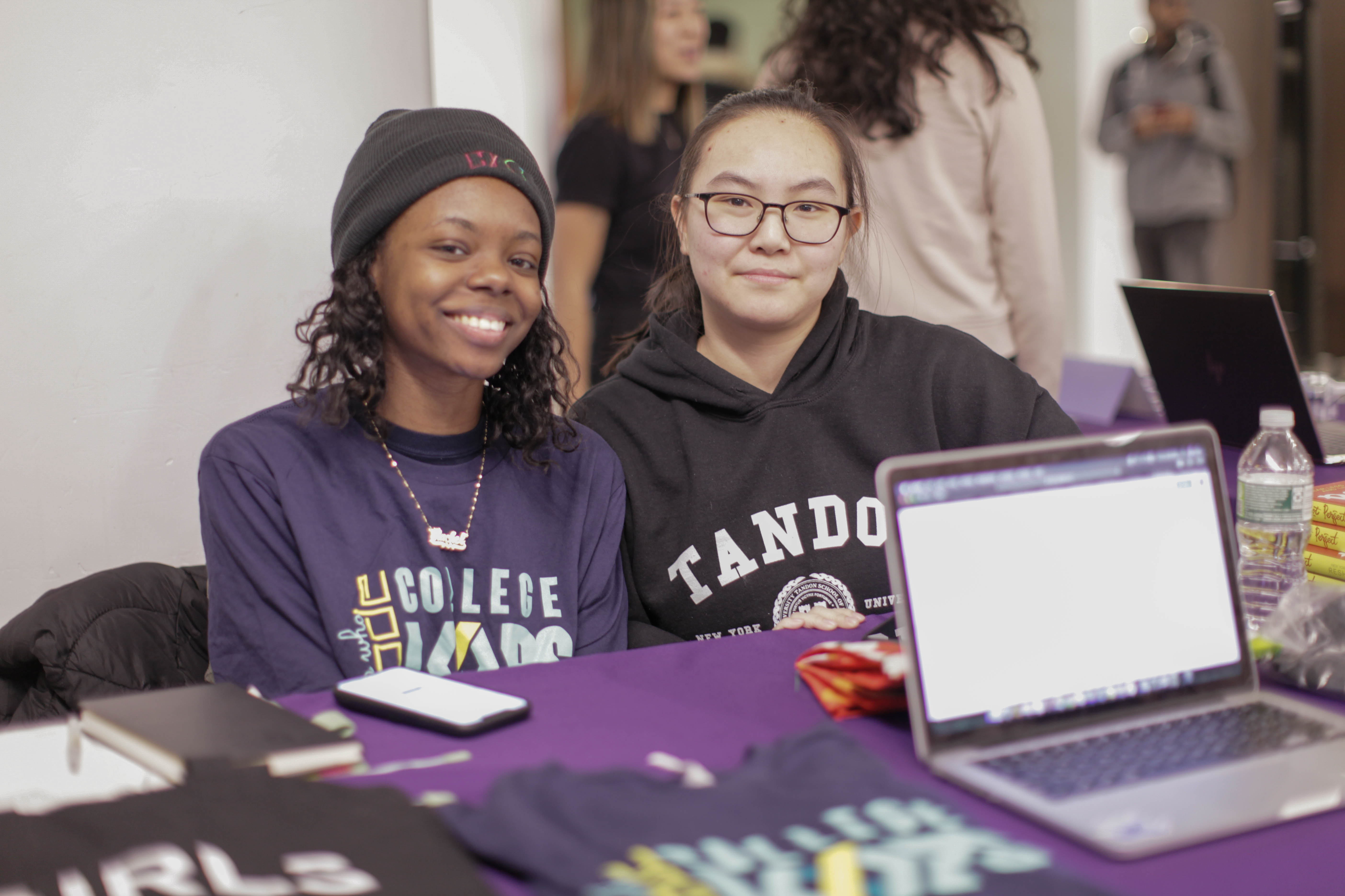 one black and one asian female students at club fest table