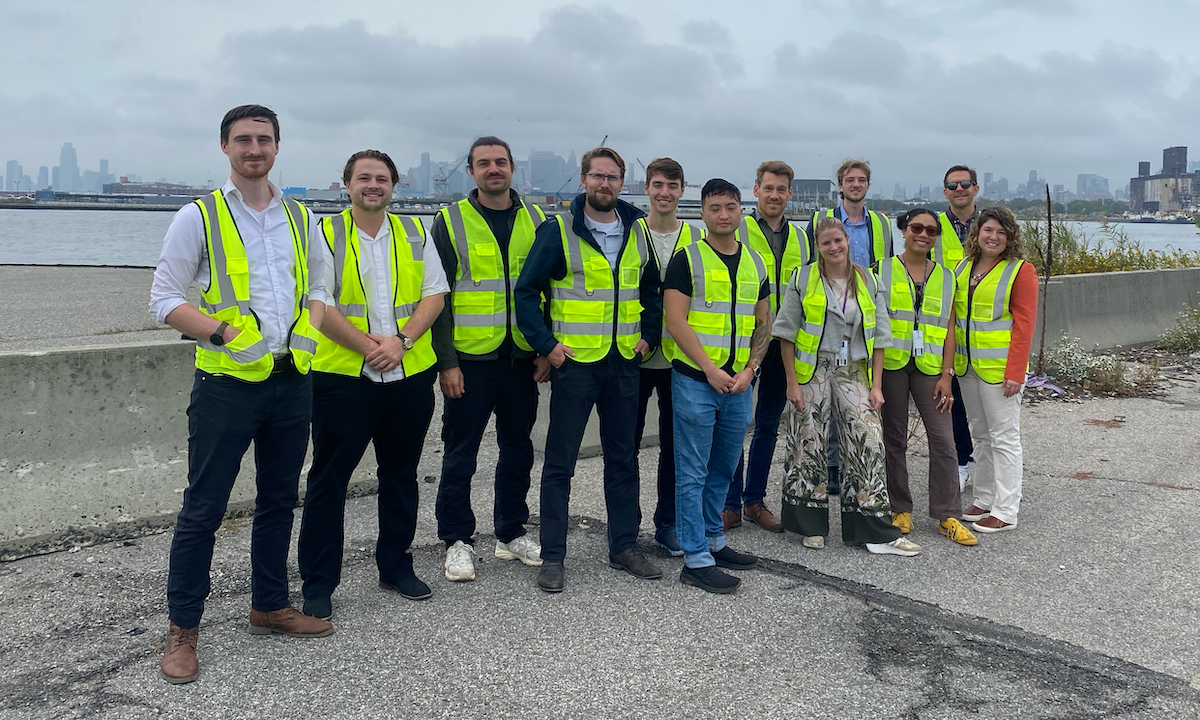 group of people wearing reflective vests standing by waterfront