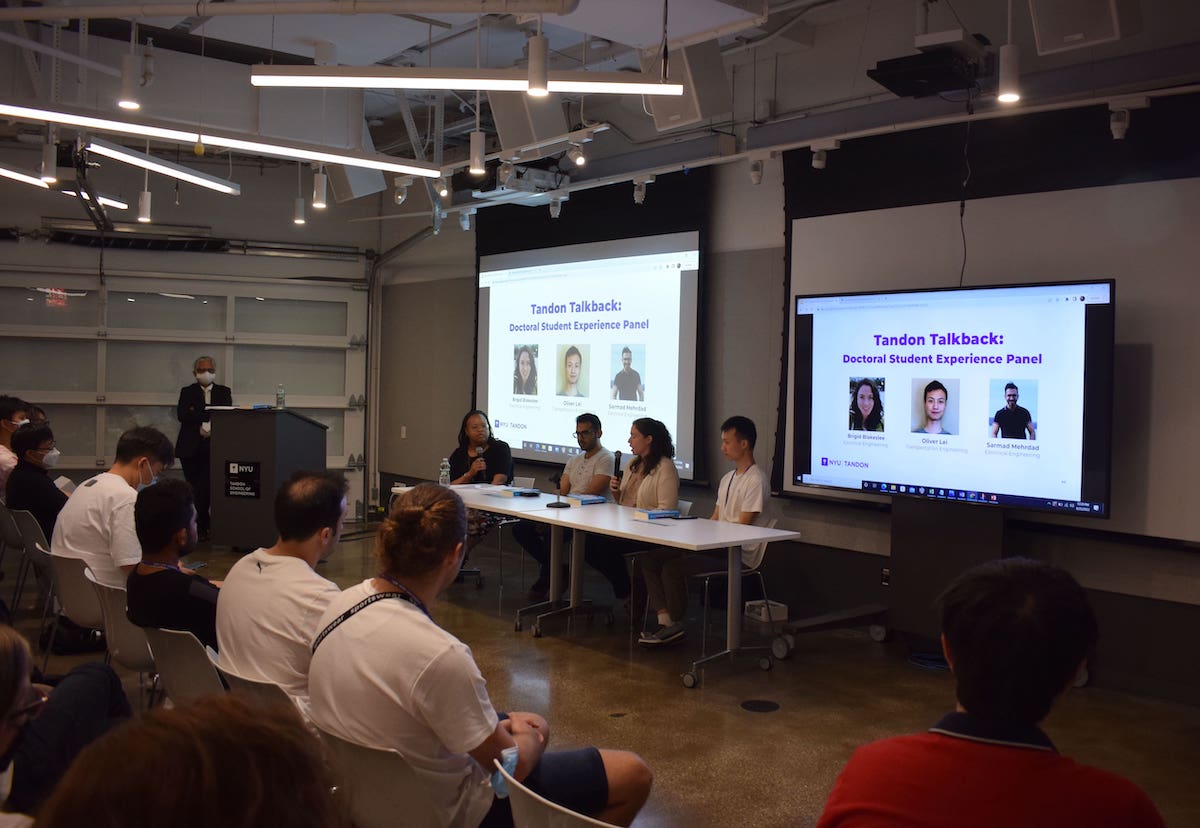 students watching a panel presentation